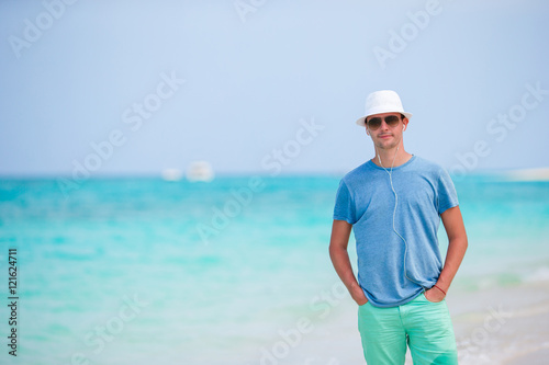 Happy young man enjoying time on white sandy beach © travnikovstudio