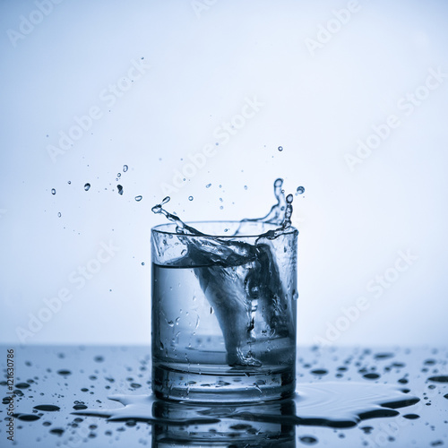 Water splash from ice cube in the glass of water