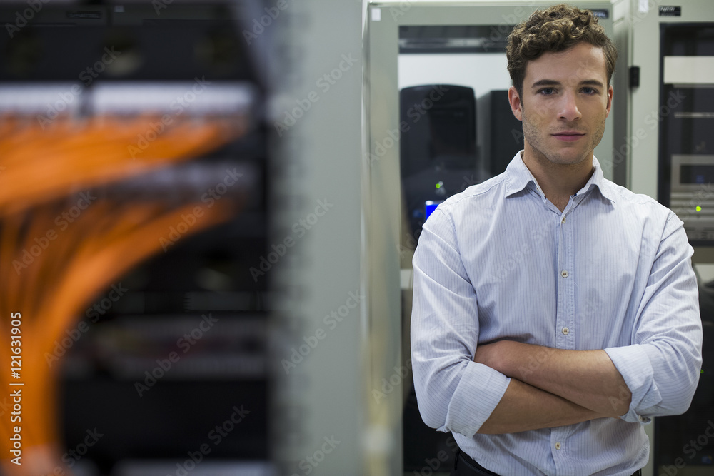Network cables connected to computer mainframe, computer technician in background