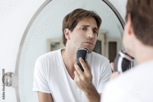 Man shaving with electric razor
