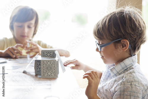 Boys building house of cards together photo