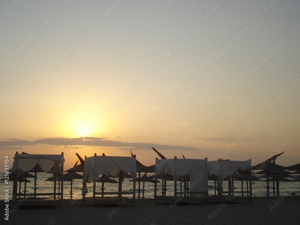 Line of beach canopies and parasols at sunrise