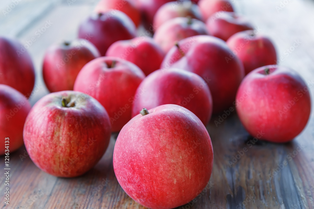 Red apples lie on a wooden table in the garden.Focus concept. Red apples lie on a wooden table in the garden.Focus concept.