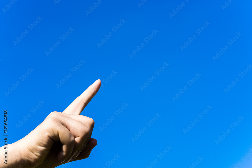Female pointing finger under blue sky Female pointing finger under blue sky