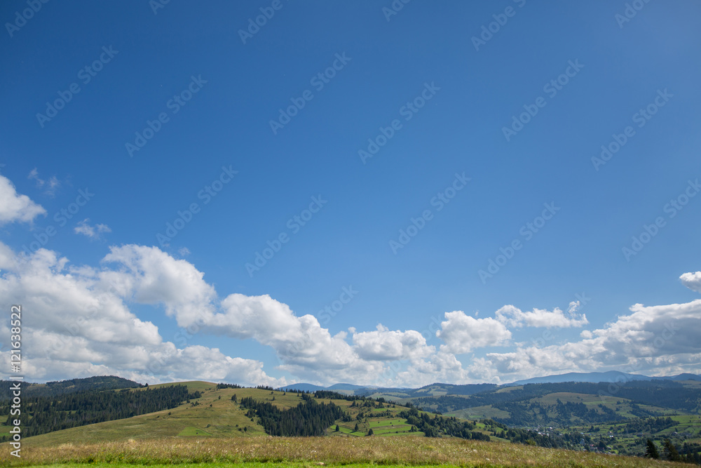 Fototapeta premium meadow, mountain and sky with clouds