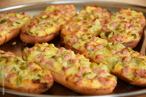 An open faced sandwich with bacon and cheese