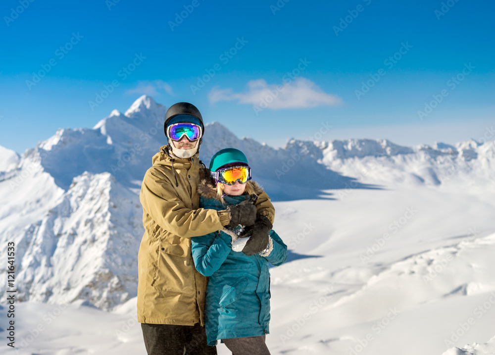 Happy couple snowboarders in mountains