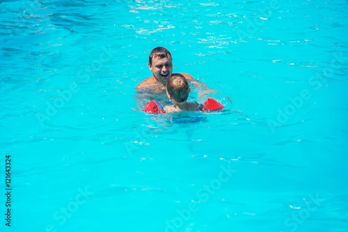 Dad and son swimming together in the pool © nata_zhekova