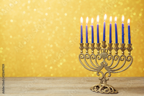 Jewish holiday Hanukkah background with vintage menorah over lights bokeh.
