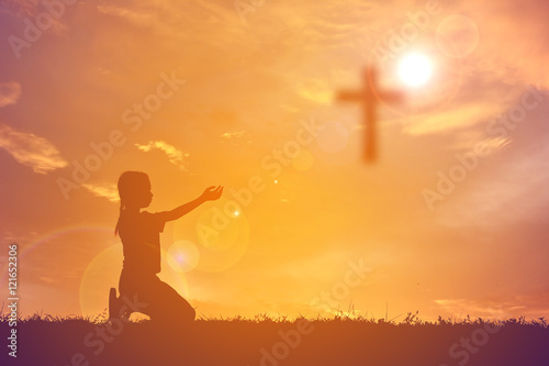 Silhouette girl with cross on sunset