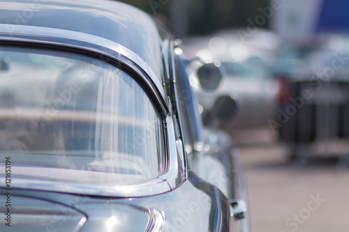 Close-up of an old car. Part of the exterior. An American classic. Chrome lining. Glass with reflection. © zhdanovdi