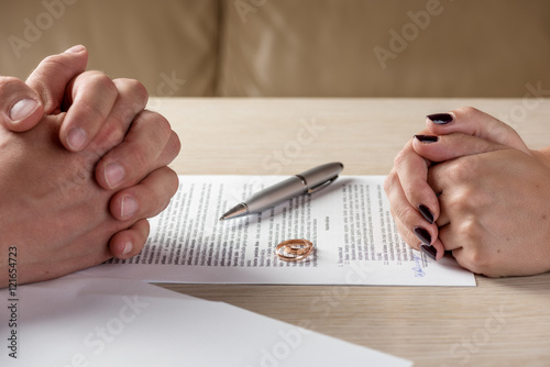 Wife and husband signing divorce documents or premarital agreement photo