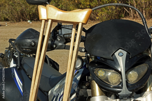 Motorcycle and crutches on the sand close up