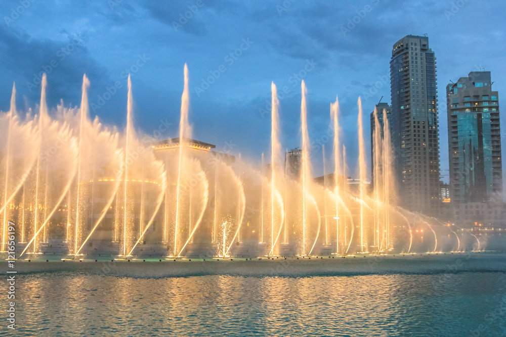 Naklejka premium Nocny widok pokazu świateł w tańczącej fontannie w Dubaju. Dubajska fontanna, największa na świecie fontanna z choreografią na obszarze jeziora Burj Khalifa, gra w rytm wybranej muzyki.