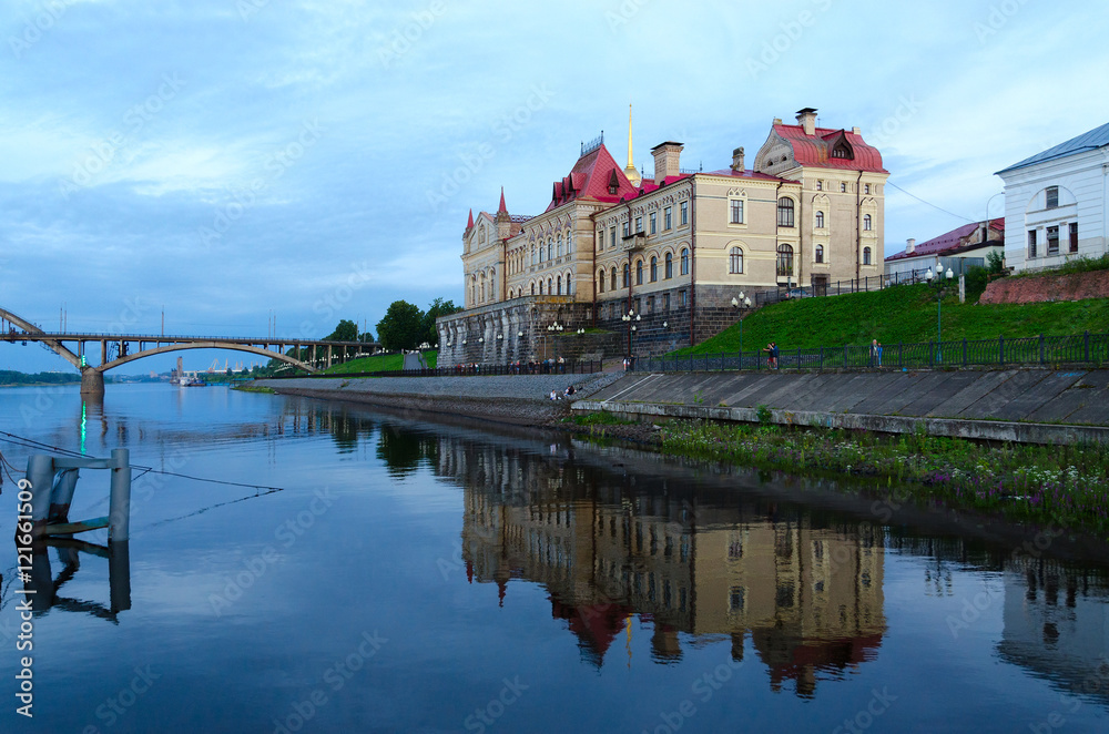 Former Grain Exchange on waterfront with reflection in water, Rybinsk, Russia