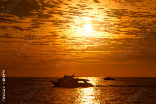 Statki na morzu podczas złocistego wschodu słońca 