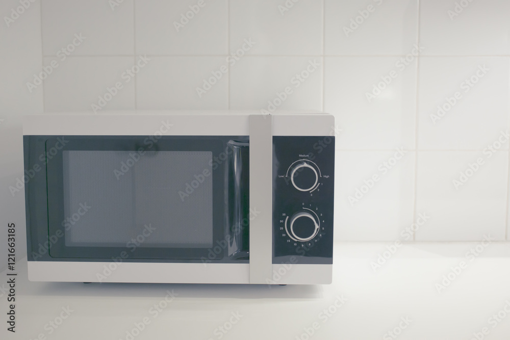 Fototapeta premium microwave in clean kitchen in vintage soft tone,simple life style concept.