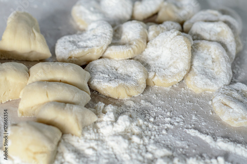 The dough rolled with circles, sprinkled flour. Making of pierog.