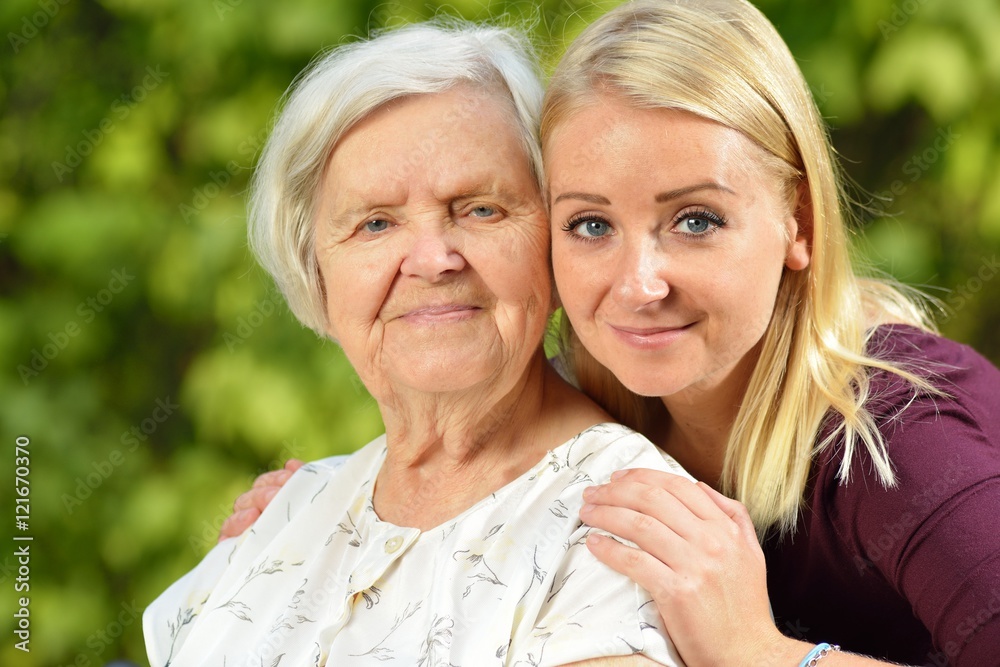 Grandmother and granddaughter. Young woman carefully takes care