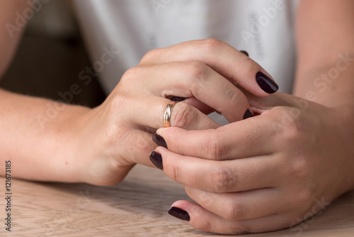 Divorce, separation: woman removing wedding or engagement ring