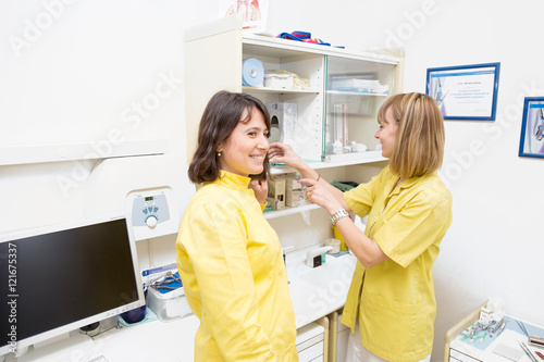 Due bellissime dottoresse in studio dentistico con il camice giallo  photo