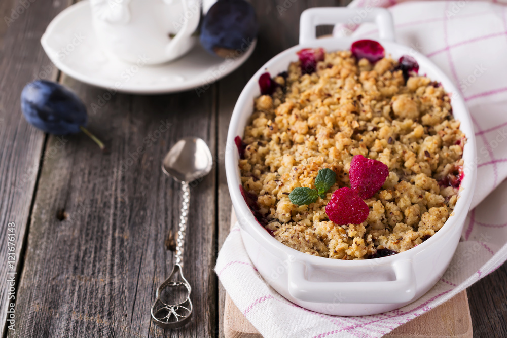 Plum and raspberry crumb on the old wooden background. Rustic style. Selective focus. Plum and raspberry crumb on the old wooden background. Rustic style. Selective focus.
