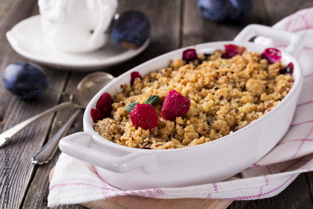 Plum and raspberry crumb on the old wooden background. Rustic style. Selective focus. Plum and raspberry crumb on the old wooden background. Rustic style. Selective focus.