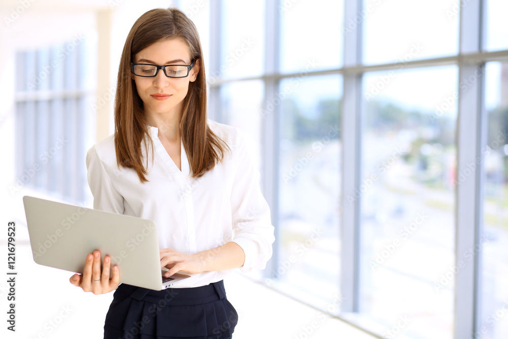 Portrait of modern business woman working with laptop computer in the office, copy space area Portrait of modern business woman working with laptop computer in the office, copy space area