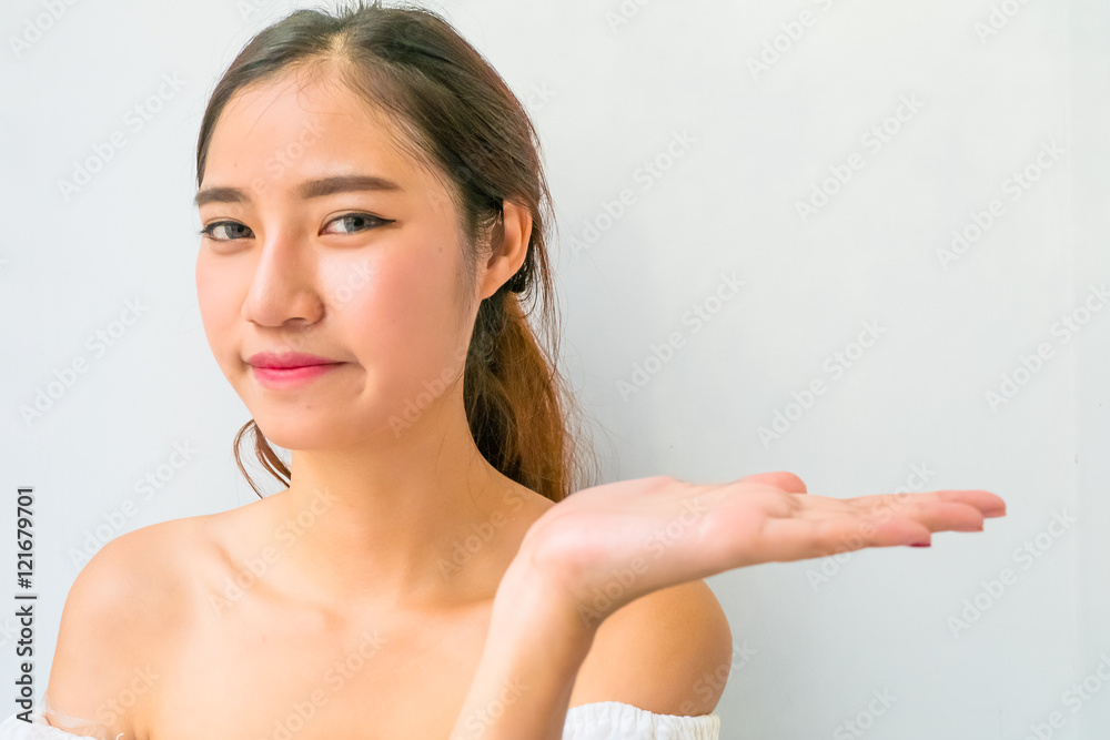 Beautiful woman with healthy clean skin presenting something on Beautiful woman with healthy clean skin presenting something on