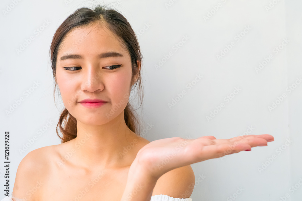 Beautiful woman with healthy clean skin presenting something on Beautiful woman with healthy clean skin presenting something on