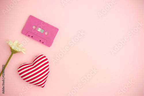Love music concept. Valentines day background with audio tape cassette, flower and a red heart.