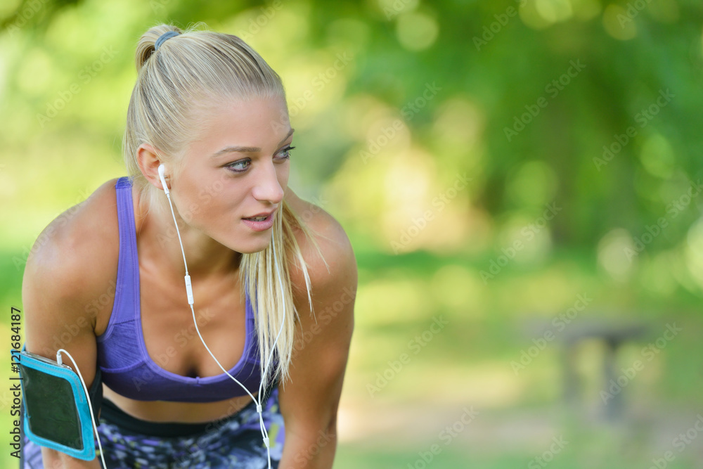 Young woman taking rest after jogging - workout at the park
