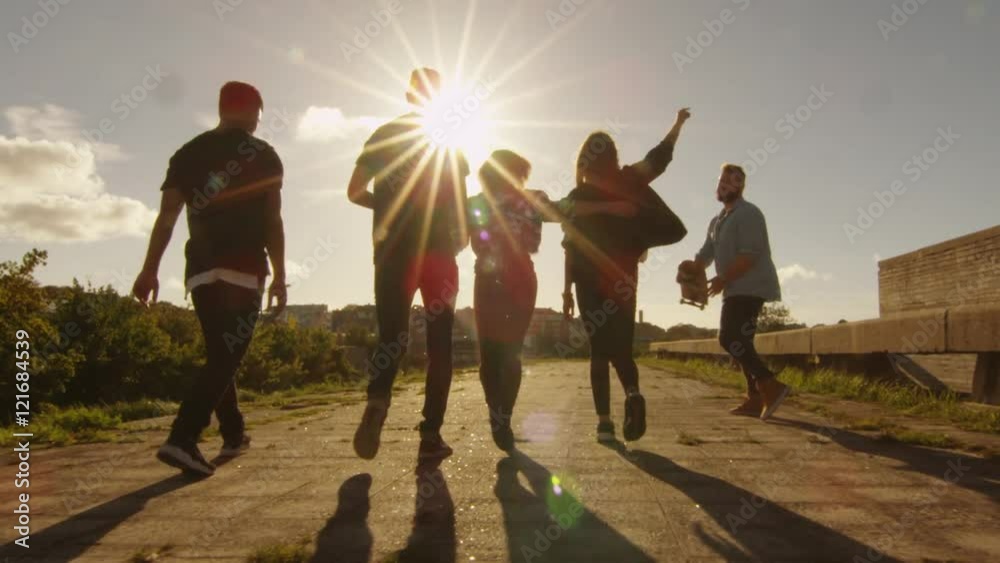Group of Happy Teenagers Laughing, Raising Hands, Jumping While Moving Outwards Camera. Shot on RED Cinema Camera in 4K (UHD).