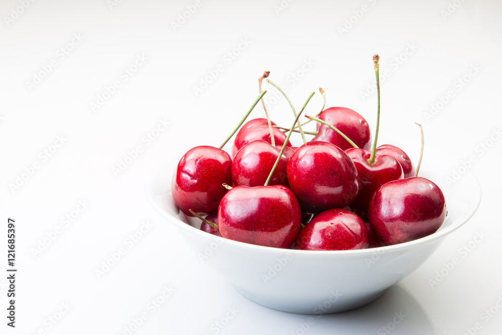 A bowl of cherries on a white background A bowl of cherries on a white background