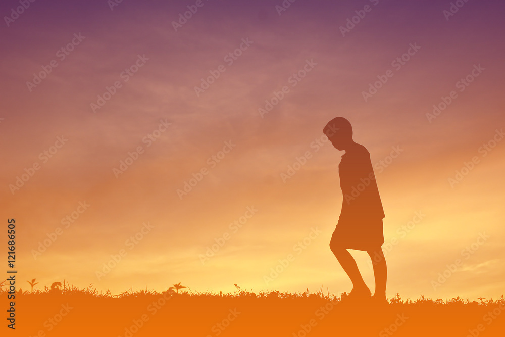 Silhouette boy alone in sunset