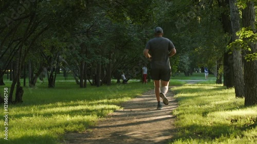 SLOW MOTION: Aged man runs on a footpath photo