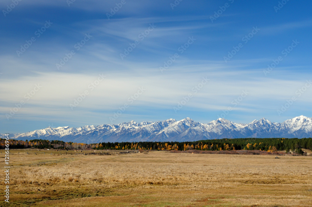blue sky over the vast steppes, Tunka valley, mountains covered with snow, Sayan mountains. Used deep toning of the photo blue sky over the vast steppes, Tunka valley, mountains covered with snow, Sayan mountains. Used deep toning of the photo