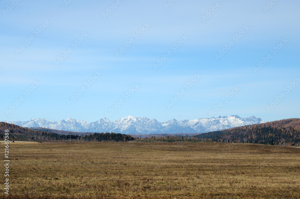 blue sky over the vast steppes, Tunka valley, mountains covered with snow, Sayan mountains. Used deep toning of the photo 