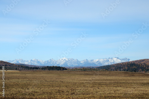 blue sky over the vast steppes  Tunka valley  mountains covered with snow  Sayan mountains. Used deep toning of the photo 