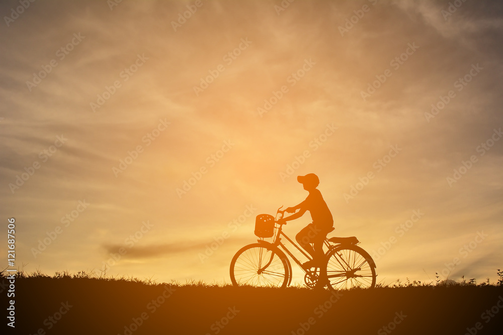 Fototapeta premium Silhouette a boy with bicycle at sunset