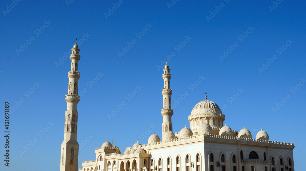 Fototapeta premium tower minaret of muslim mosque in front of azure blue sky