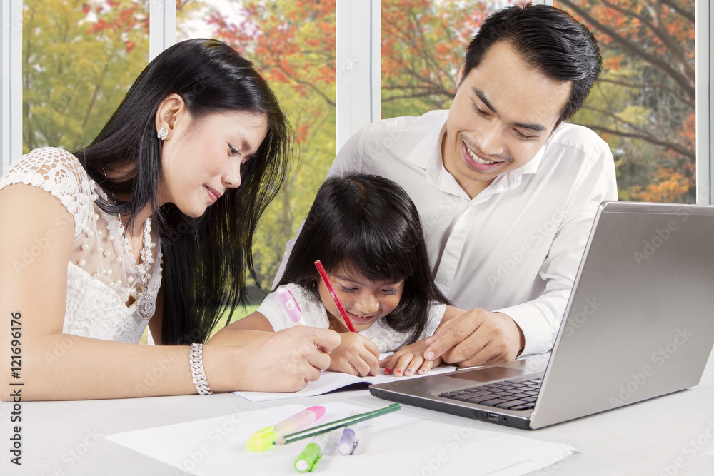 Female child studying with her parents
