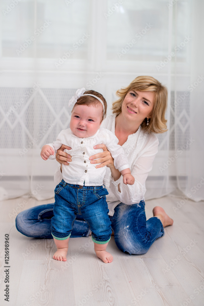 Mom teaches her little daughter stand at home. Vertical Mom teaches her little daughter stand at home. Vertical