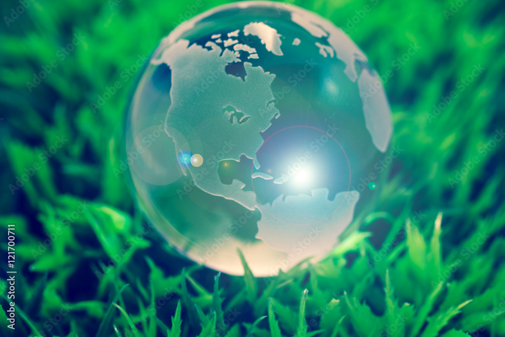Crystal globe on green grass, with lens flare