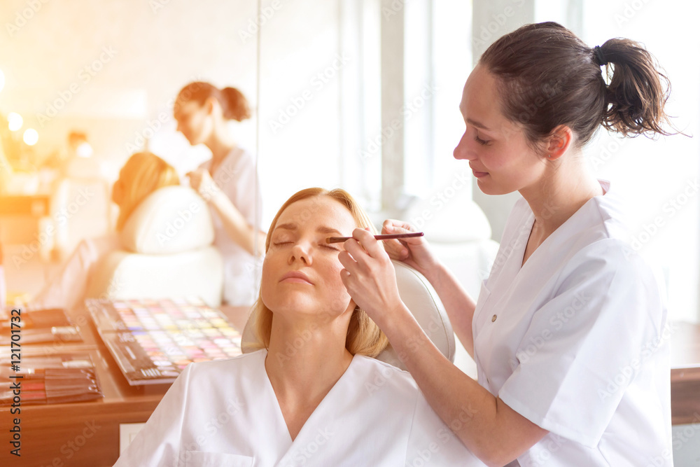Two young beautician students working during make up classes Two young beautician students working during make up classes