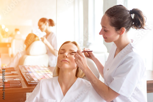 Two young beautician students working during make up classes