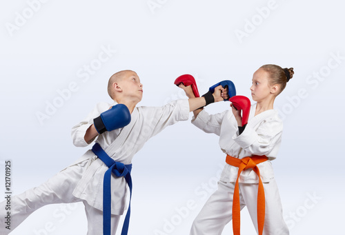 Boy beats punch girl standing in the rack karate