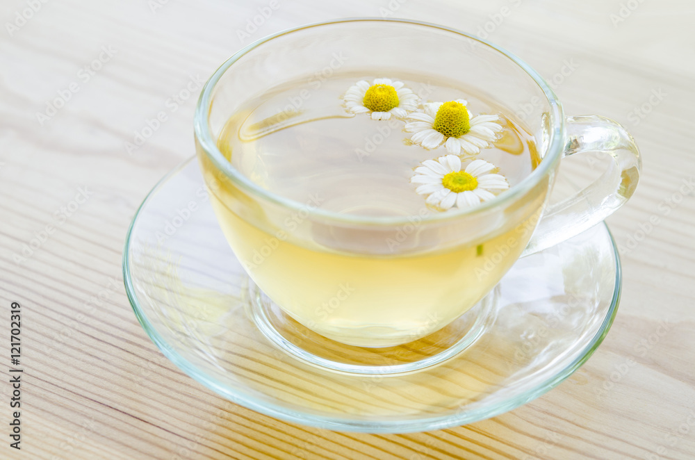 Cup of medicinal chamomile tea on the wooden table