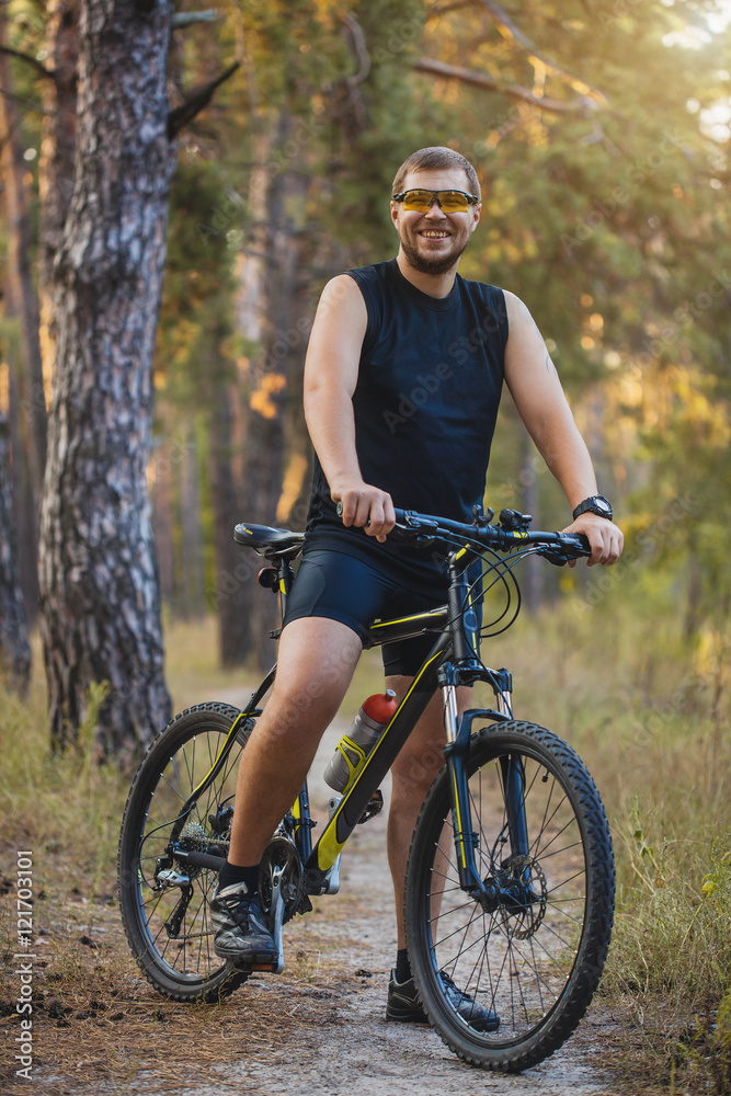 Obraz premium man cyclist rides forest paths