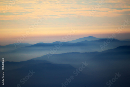 blue profiles of mountains in a misty sunset © valeconte